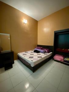 um quarto com uma cama e uma televisão em DeSyafiq Homestay em Kuala Kedah