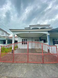 uma casa com uma cerca vermelha em frente em DeSyafiq Homestay em Kuala Kedah