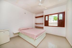 um pequeno quarto com uma cama e uma janela em ApartaHostal Mafelo em Taganga