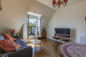 a living room with a couch and a piano at Paris Centre Dernier Étage Vue Ascenseur in Paris