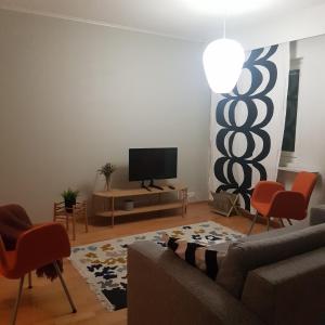 a living room with a couch and a flat screen tv at Tilava kolmio keskustassa in Ylivieska