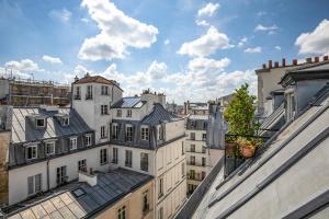 a view of the roofs of buildings in a city at Paris Centre Dernier Étage Vue Ascenseur in Paris