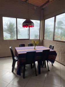 a dining room with a table and chairs and a chandelier at tierrabrava-hospedaje in Cojimíes