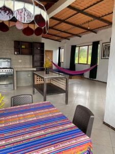 a dining room with a table and chairs and a hammock at tierrabrava-hospedaje in Cojimíes