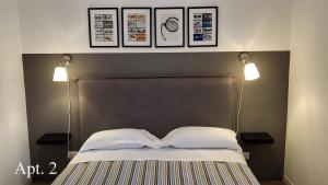 Una cama con dos luces encima. en MeModena Apartments, en Módena