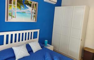 1 dormitorio azul con 1 cama y 2 ventanas en sea ottiolu, en Porto Ottiolu