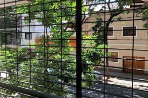una ventana con vistas a un edificio con un árbol en el exterior en Hermoso dpto.2 ambientes. Luminoso en Buenos Aires