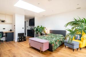 1 dormitorio con 1 cama y sala de estar en Modern Studio with parking in private garden, en Theydon Bois