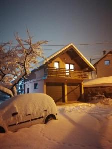 Una furgoneta cubierta de nieve frente a una casa en Sweet House, en Pale