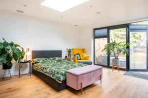 Modern Studio with parking in private garden في Theydon Bois: غرفة نوم بسرير كبير وأريكة