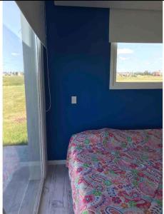 een blauwe slaapkamer met een bed en een raam bij Excelente Casa Country in Oliden
