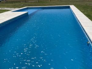 een zwembad met blauw water in een tuin bij Excelente Casa Country in Oliden