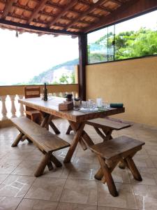 Santo Mirante Hostel في ريو دي جانيرو: طاولة وكراسي خشبية في الغرفة