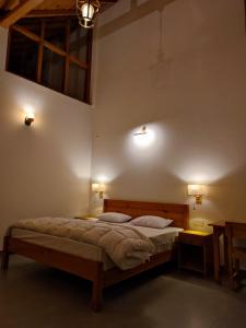 1 dormitorio con 1 cama y 2 luces en la pared en Ziran retreat en Mukteswar
