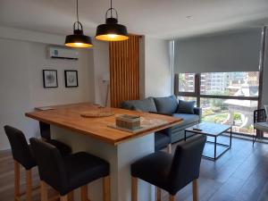 a kitchen and living room with a table and a couch at ALTOS DE STELLA MARIS Excelente Departamento y ubicación in Mar del Plata +11 photos