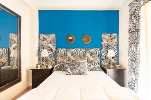 een slaapkamer met een groot bed met een blauwe muur bij Casa Mundial Jerez in Jerez de la Frontera