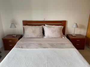 ein Schlafzimmer mit einem großen Bett mit zwei Nachttischen in der Unterkunft Apartamento da vila, Porto Santo. in Vila Baleira + 12 Fotos