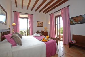 a bedroom with a large bed with pink curtains at Hotel Son Trobat Wellness & Spa in Sant Llorenç des Cardassar