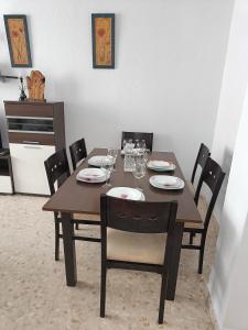 uma mesa de jantar com cadeiras e uma mesa de madeira em PISO EN 2* LINEA DE PLAYA em Barbate
