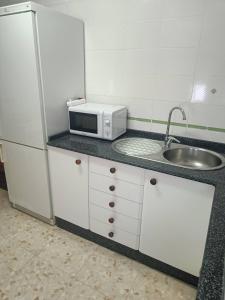 a kitchen with a sink and a microwave at PISO EN 2* LINEA DE PLAYA in Barbate