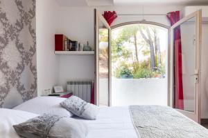 ein Schlafzimmer mit einem Bett und einem großen Fenster in der Unterkunft Le Mas des Roches à Velaux in Velaux