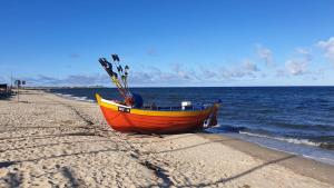 an orange and yellow boat sitting on the beach at Fajna Cavalera in Reda