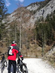 um homem segurando uma bicicleta em uma estrada de terra em Seehof Royer em Obertraun