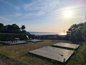 un campo con mesas y sillas y el océano en Keryanne, en Saint-Gildas-de-Rhuys