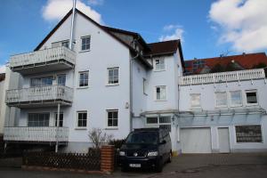 a white house with a car parked in front of it at Ferienwohnung mit 4 Schlafzimmer für 2 bis 9 Gäste----Apartment with 4 bedrooms for 2 to 9 guests in Nuremberg