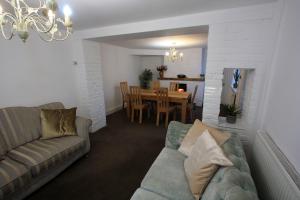 uma sala de estar com um sofá e uma sala de jantar em Lymm Cottage em Lymm