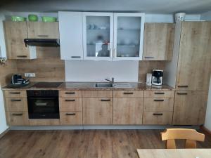 una cocina con armarios de madera y fregadero en Seehof Royer en Obertraun