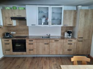 a kitchen with wooden cabinets and a sink at Seehof Royer in Obertraun