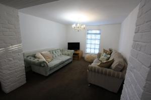 a living room with two couches and a tv at Lymm Cottage in Lymm