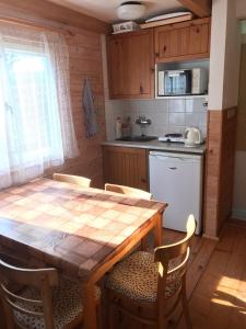 eine Küche mit einem Holztisch und Stühlen sowie einem Tisch und einem Tisch in der Unterkunft Chaty U Žabáka in Netolice