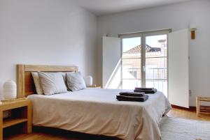 - une chambre avec un grand lit et une grande fenêtre dans l'établissement Casa Valerie - Etramures, à Tavira