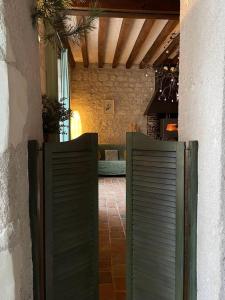 an entrance to a house with two green gates at Le Relais, La Dormance, Le Bois Dormant in Châteauvieux