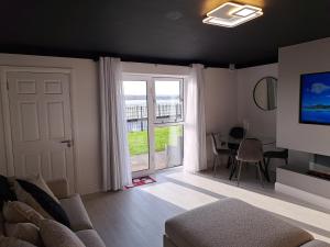 uma sala de estar com um sofá, uma televisão e uma mesa em SeaView Apartment Suite em Cobh