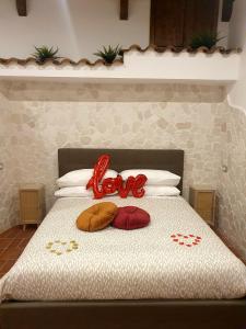 Una cama con dos almohadas con la palabra amor en ella en Setteabbracci Suite & Apartments, en Baronissi