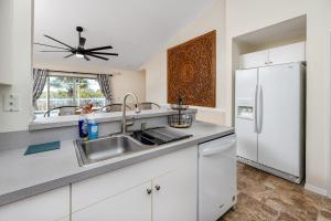 een keuken met een wastafel en een koelkast bij Blue Heron Lakeview Pool Home Close to Clearwater in Largo