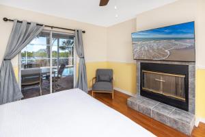 een slaapkamer met een bed en een open haard bij Blue Heron Lakeview Pool Home Close to Clearwater in Largo