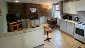 cocina con armarios blancos y encimera en The Slates Apartments - Fuchsia & Orchard Apartments en Irvinestown