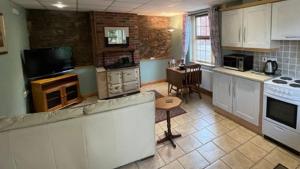 a kitchen with white cabinets and a counter top at The Slates Apartments - Fuchsia & Orchard Apartments in Irvinestown