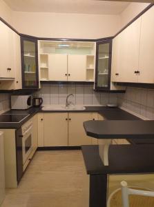 - une cuisine avec des placards blancs et un évier dans l'établissement MARIOS HOUSE 1, à Xánthi