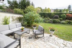 a patio with a couch and chairs and a yard at Peace-Deluxe**** in Bingen am Rhein