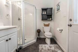 Un baño blanco con ducha y WC. en The Hacienda, Themed Guesthouse with Pool, en Oak Ridge