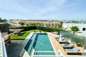 an apartment with a swimming pool on the roof of a building at Ferragudo Premium Villa - heatable pool & river views in Ferragudo
