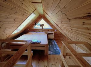 um quarto numa casa na árvore com uma cama e uma janela em KTA TARPAN Mały Domek em Masiewo