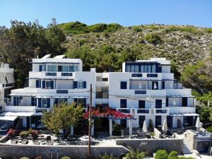 ein weißes Gebäude mit einem Hügel im Hintergrund in der Unterkunft Chios Xenia Studios & Apartments in Paralia Agias Foteinis