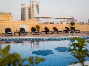 a pool with chairs and umbrellas on a building at Arabian Dreams Hotel Apartments in Dubai +13 photos