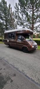 a brown van with a surfboard on top of it at RETRO CAMPER HIRE LTD Campervan Hire Company "Travel Throughout Ireland " in Dublin